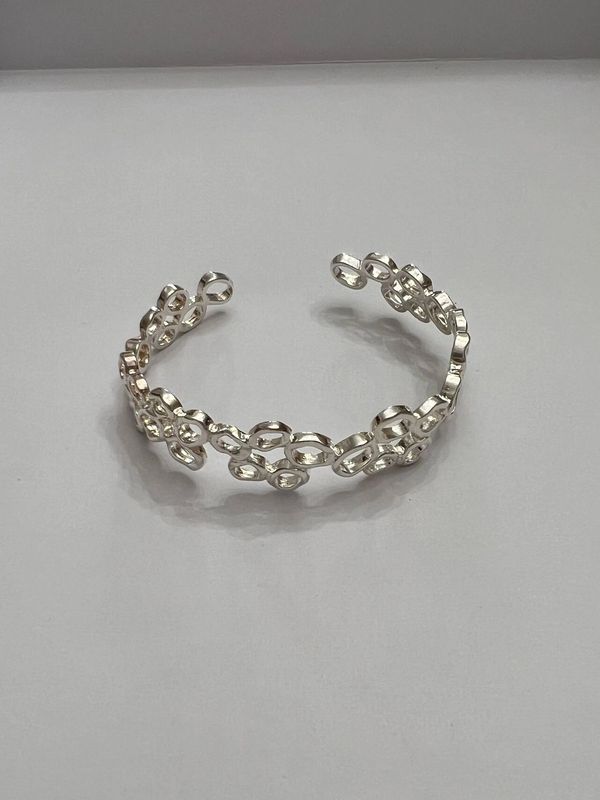 Open cuff chain-link style bracelet with a silver tone finish.