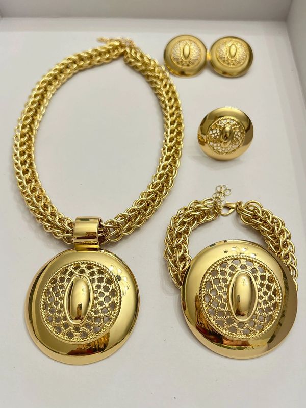 Statement medallion necklace bracelet ring accessory set.
