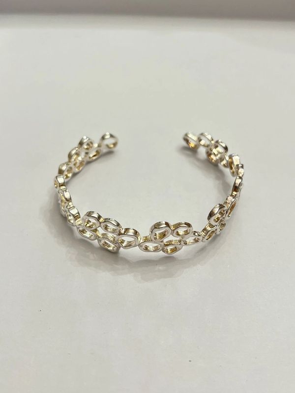 Open cuff chain-link style bracelet with a two-toned finish.