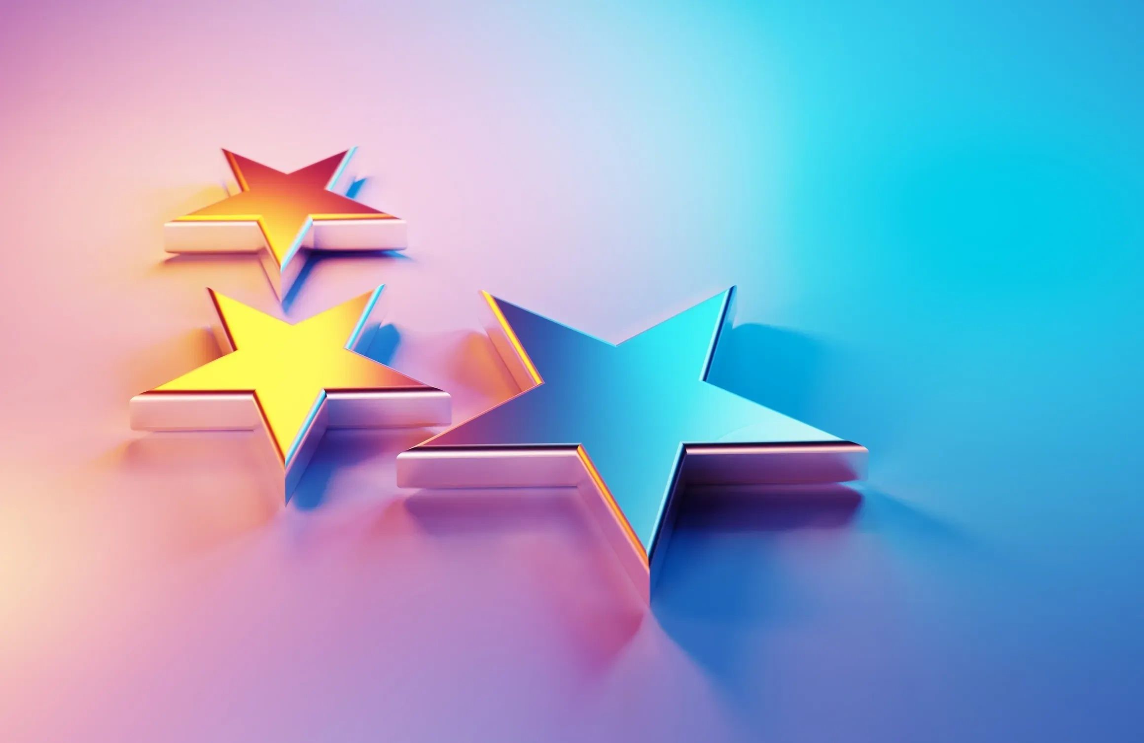 Three glossy stars with vibrant gradient lighting on a smooth surface.