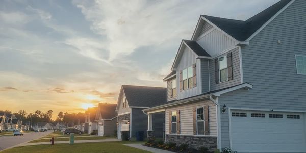 Sunset over a quiet suburban street with modern houses.