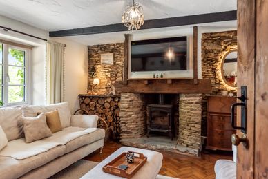 Cozy living room with stone fireplace and beige sofa.