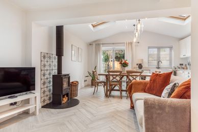 Cozy living room with wood stove and dining area.