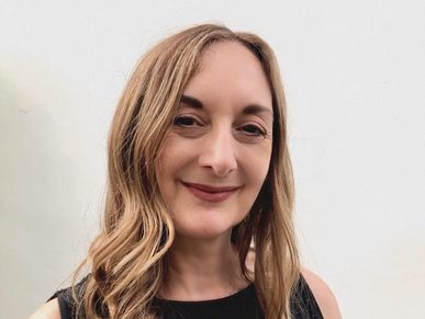 Melina Sarra-May, international therapist and clinical supervisor, smiling, looking empathic.