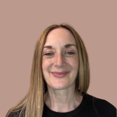 Smiling woman with long straight hair against a plain background.