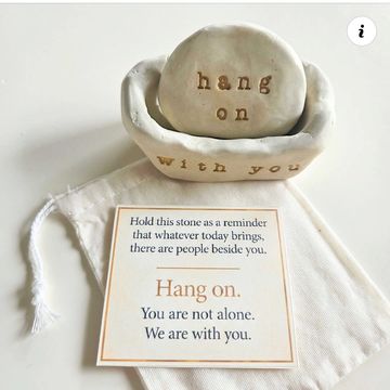 A stone with the message "hang on with you" and an encouraging note.