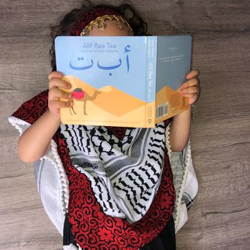 Palestinian child reading an Arabic children's book 