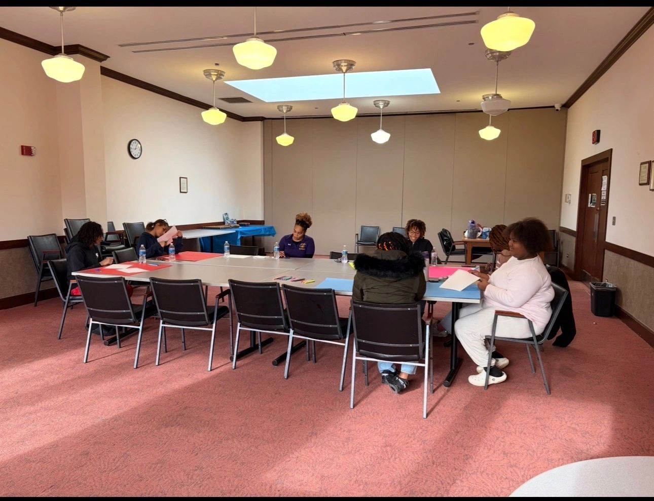 People seated around a large table in a meeting room.