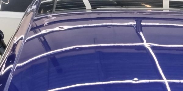 Reflection on a shiny blue car roof.