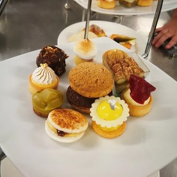 Assorted gourmet mini desserts arranged on a white plate.