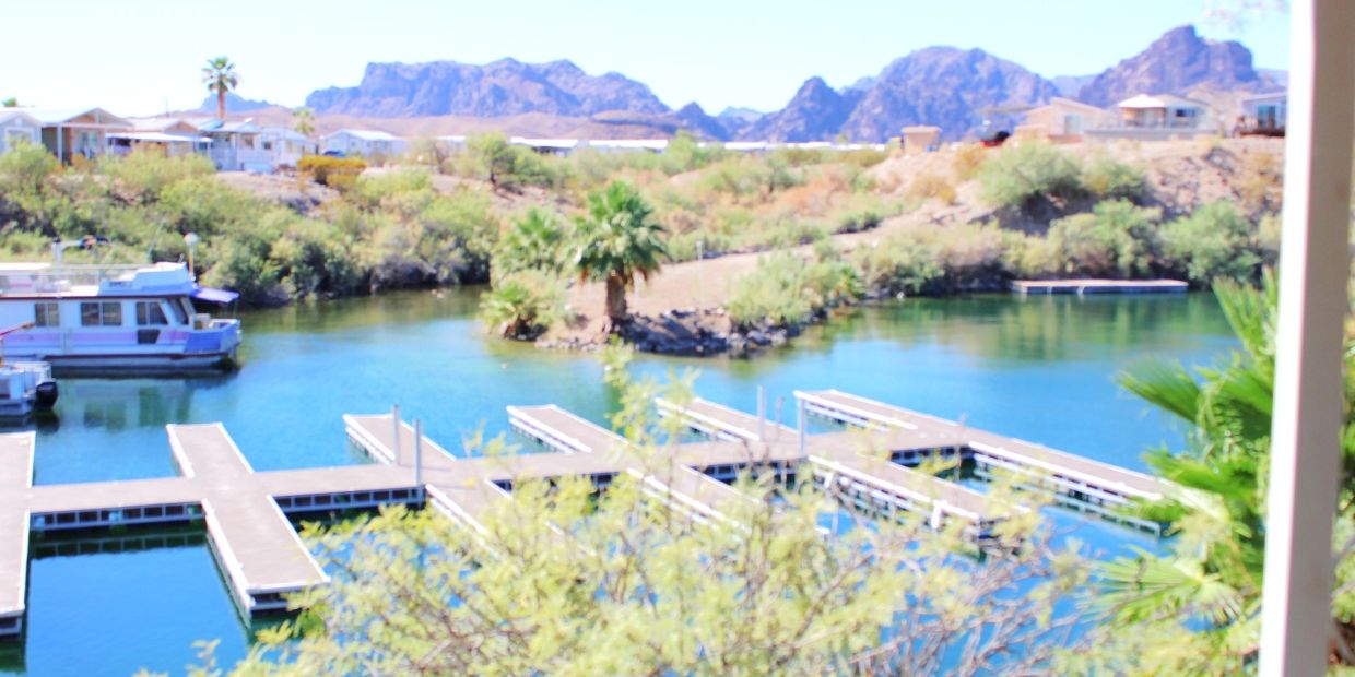 Boat docks on a serene lake with mountains in the background.