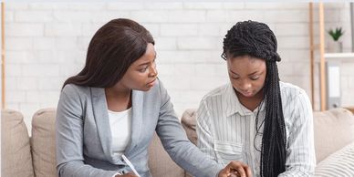 A woman consoling another woman who looks distressed.