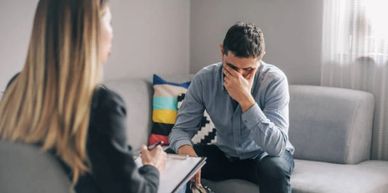 Man in distress talking to a therapist in a counseling session.