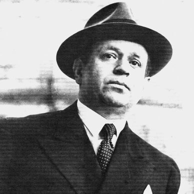 Black and white portrait of a man in a suit and hat from the early 20th century.