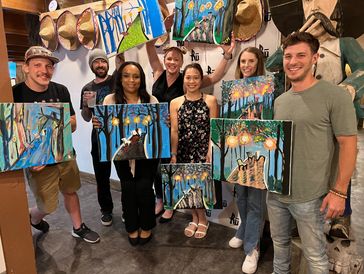 Group of people holding paintings