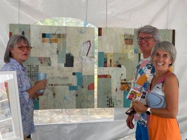 Trois femmes devant des œuvres d'art abstraites dans une galerie.