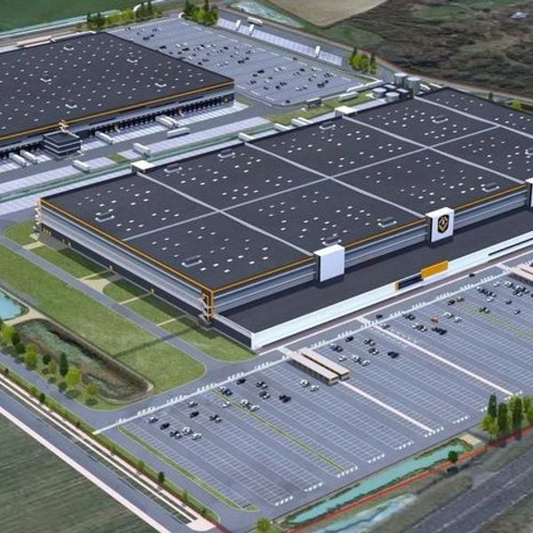 A large industrial warehouse with ample parking and surrounding greenery.