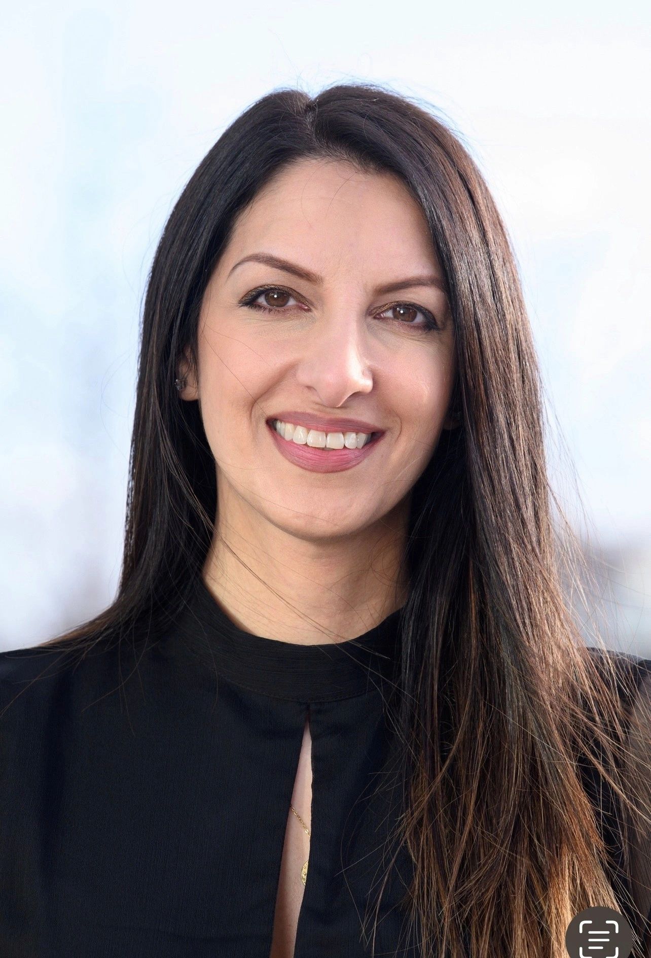 Smiling woman with long dark hair and black top.