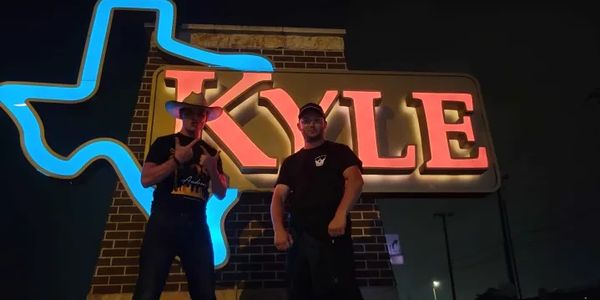 The Kyle, Texas sign glows softly against the night sky, warmly welcoming visitors to the town.