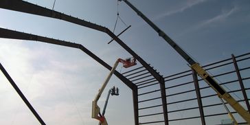 Construction workers assembling a steel building frame.