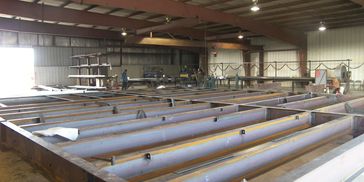 Large steel beams inside an industrial warehouse.