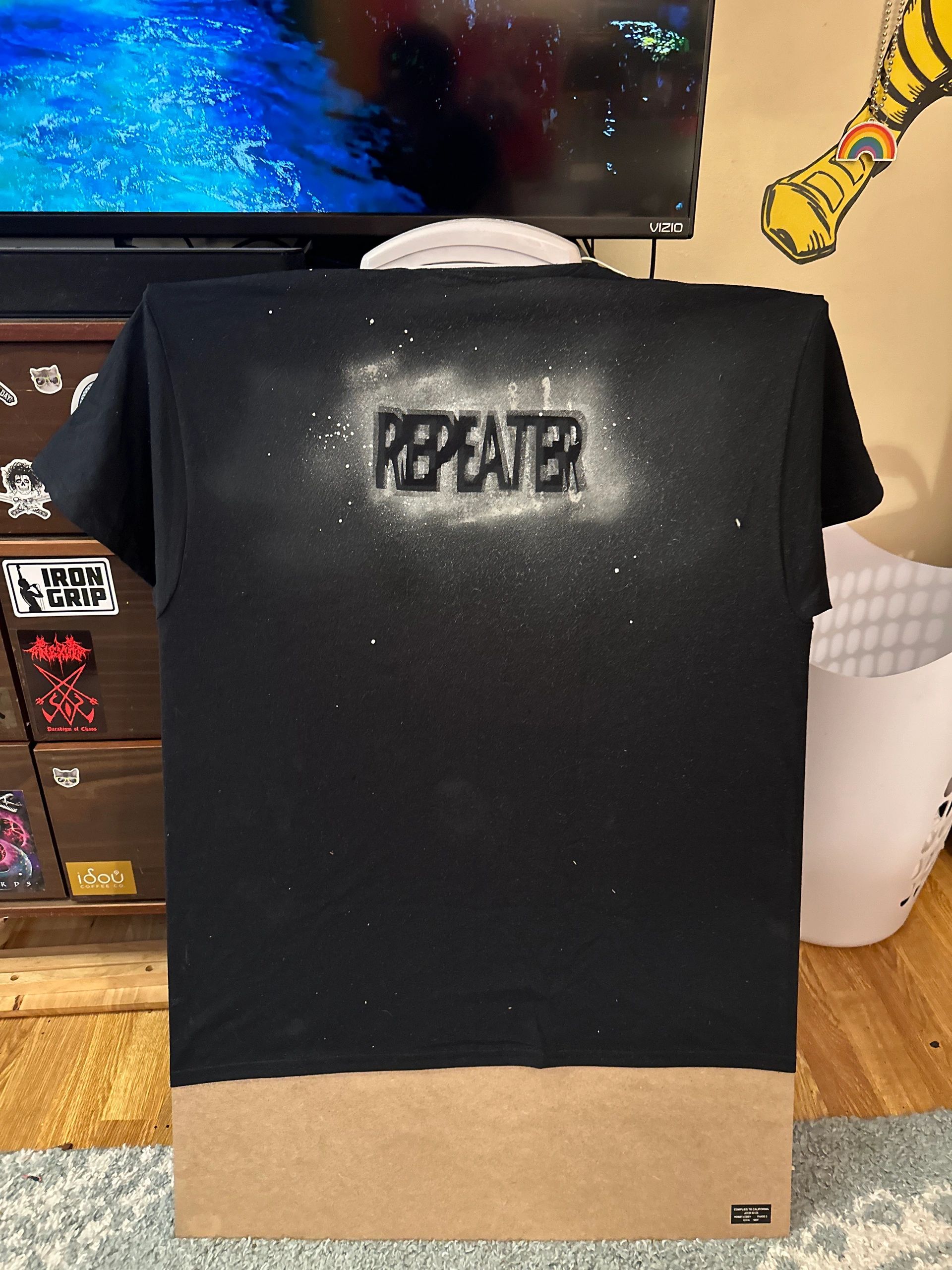Black t-shirt with white spray paint text 'REPEATER' on the back.