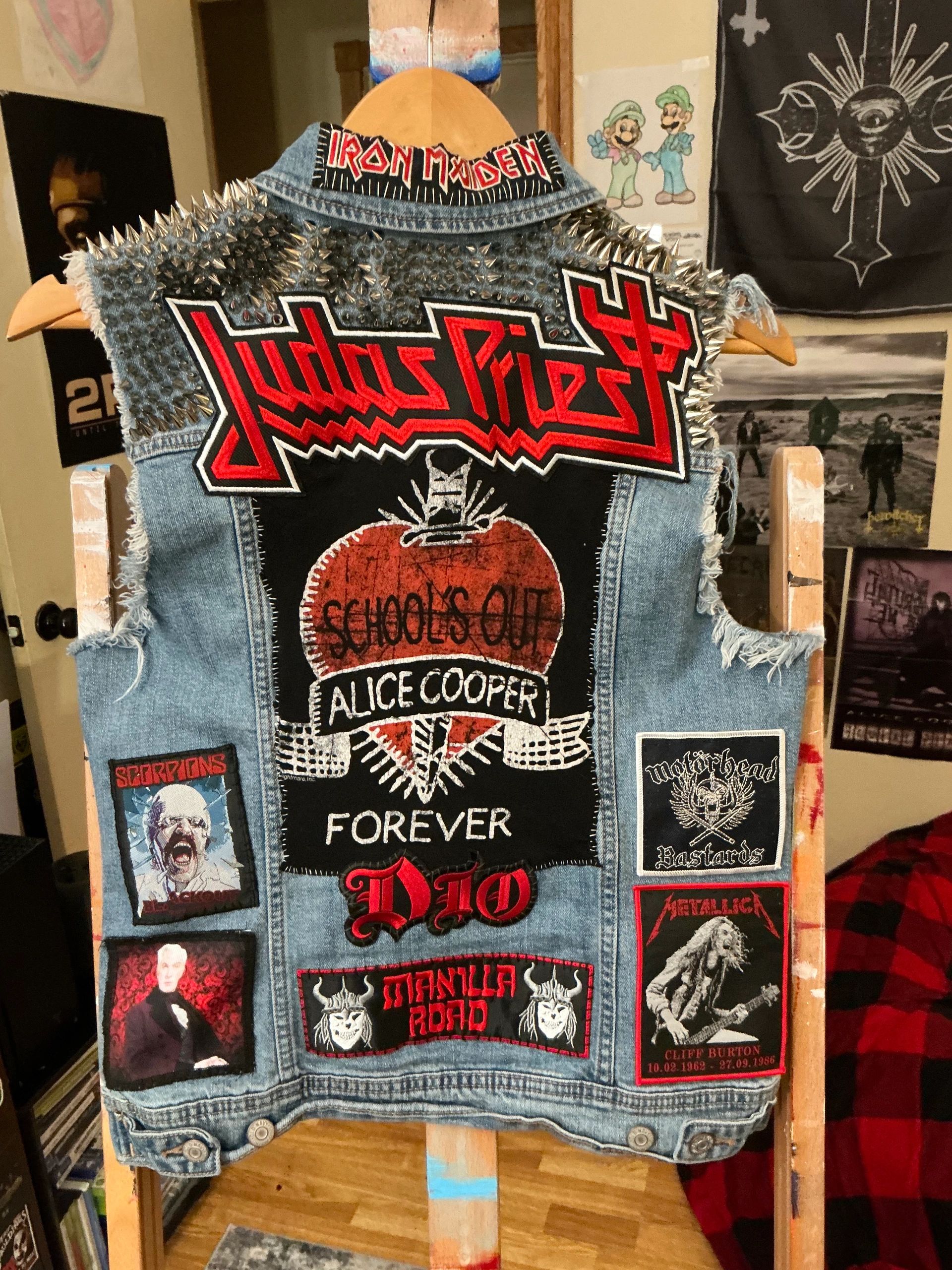 Studded denim vest adorned with classic heavy metal band patches.
