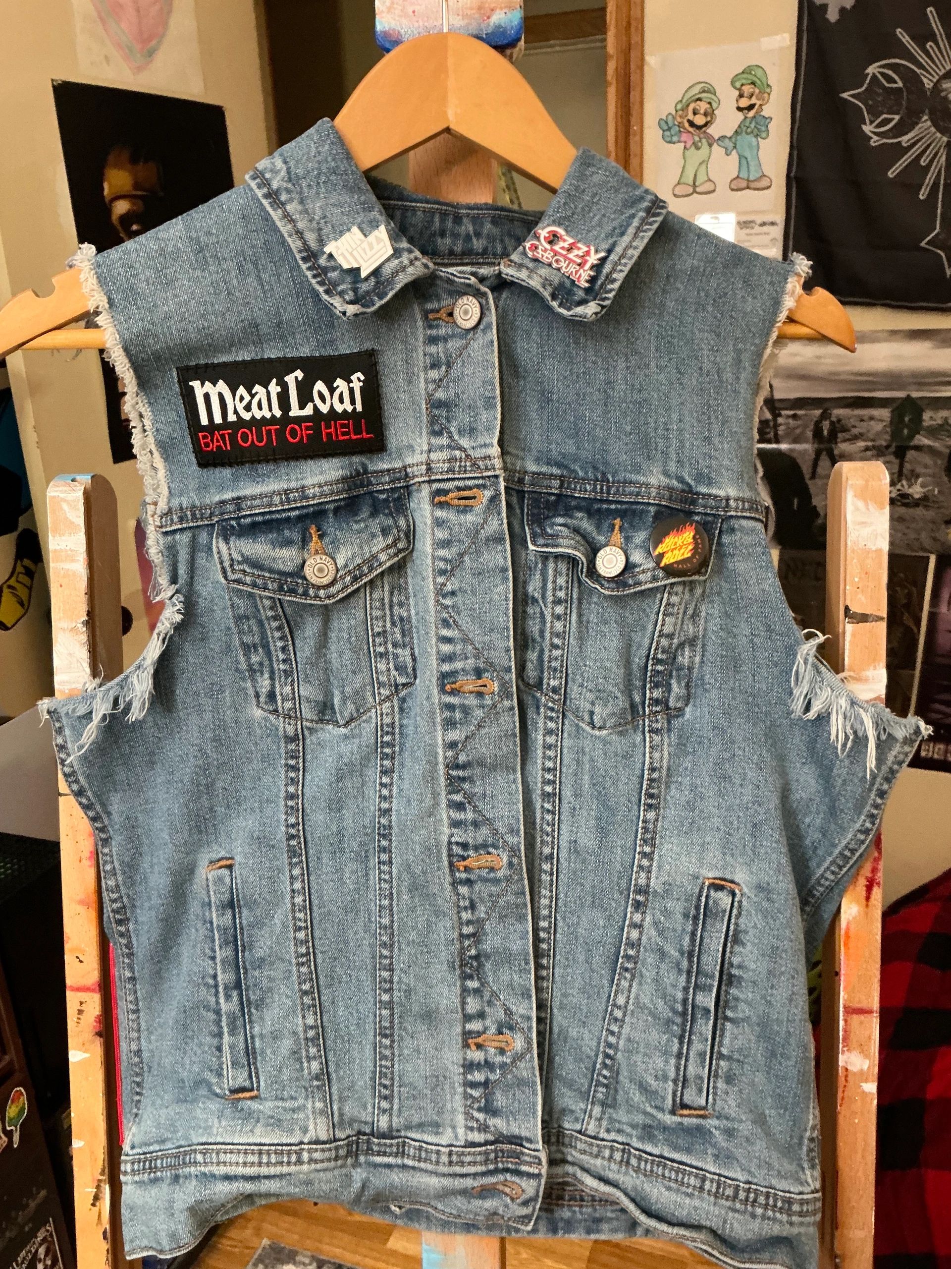 Denim vest adorned with classic rock band patches and pins.