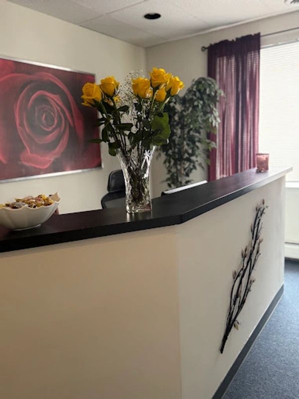 Reception desk with yellow roses and bowl of candy.