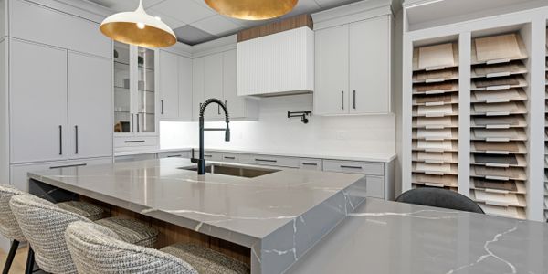 Modern kitchen with marble countertops and white cabinetry.
