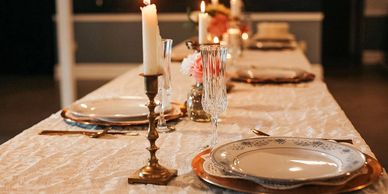 Elegant dining table with candles and floral decorations.
