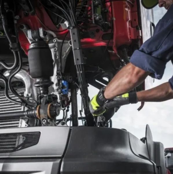 Mechanic working on a vehicle engine with gloves.