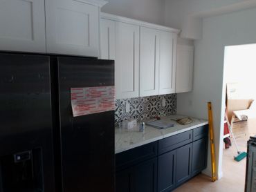 Modern kitchen with white upper cabinets and dark lower cabinets.