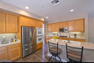 Modern kitchen with wooden cabinets and stainless steel appliances.
