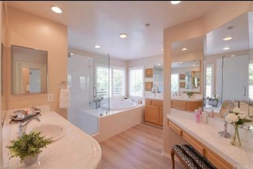 Bright, modern bathroom with dual sinks and a large bathtub.