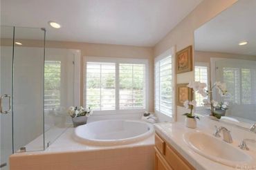 Bright bathroom with bathtub and shower enclosure.