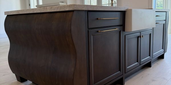 Elegant dark wood kitchen island with marble countertop.