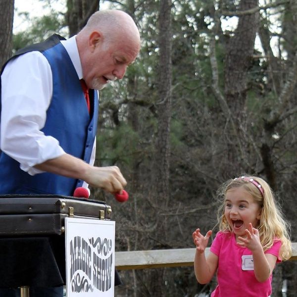 JIm doing magic for an excited little girl