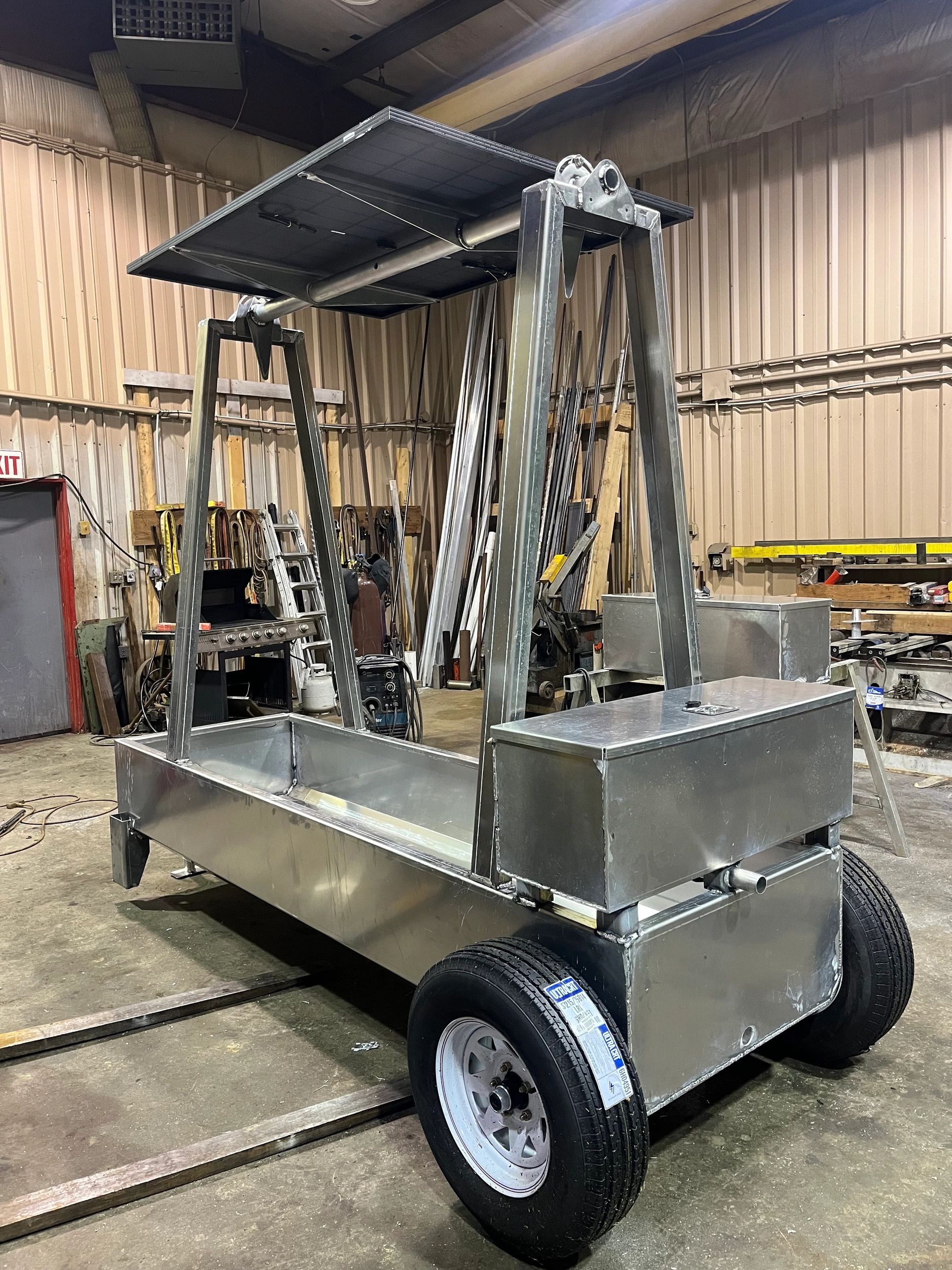 Metal frame structure with wheels inside a workshop.