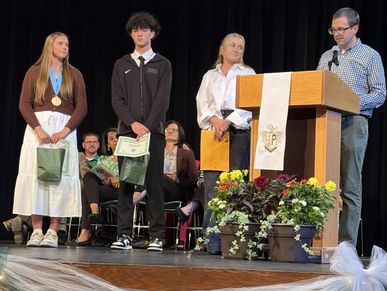 Students receiving awards on stage during a ceremony.