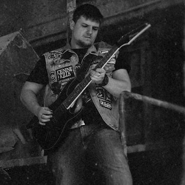 Musician passionately playing electric guitar in a gritty, industrial setting.