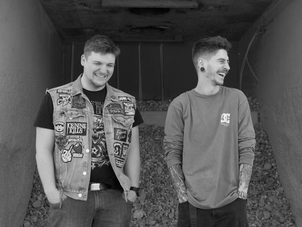 Two young men laughing together in a tunnel.