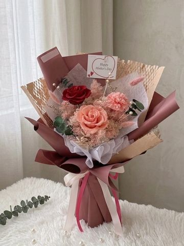 Elegant Mother's Day bouquet with roses and carnations in pink and red hues.