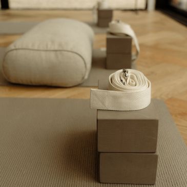 Yoga props arranged on a mat indoors.