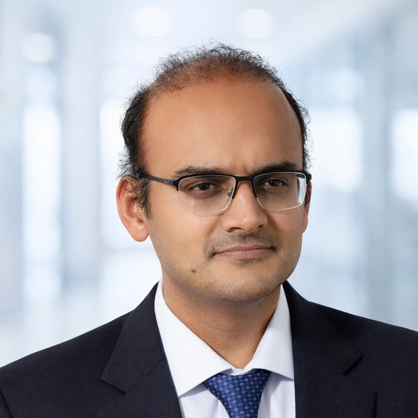 Professional man in suit and glasses with a confident expression.