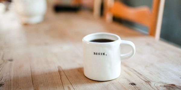 White Coffee cup with the phrase 'Begin.'