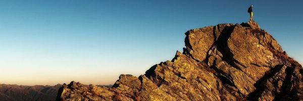 Person standing on top of a rock outcrop.