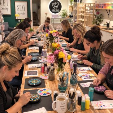 Group painting colorful dot mandalas at an art studio.