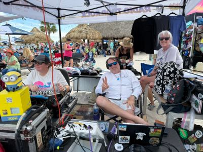 People relaxing under a tent at an outdoor market.