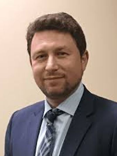 Man in suit with a slight smile.